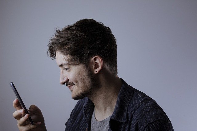Muž se dívá na telefon